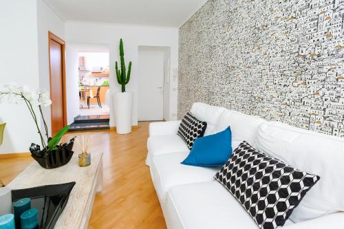 a living room with a white couch and a brick wall at Nipare Suite - Dimore Partenopee in Naples