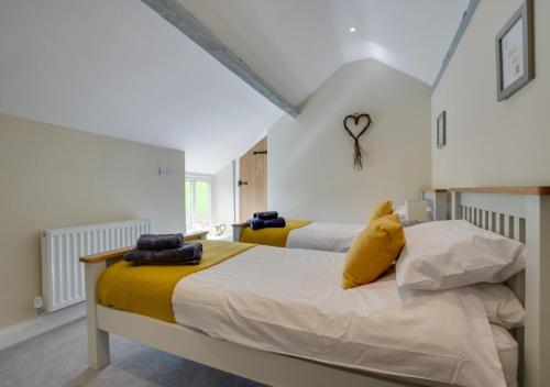 a bedroom with two beds with yellow pillows at Ty Isa in Llanfair Talhaiarn