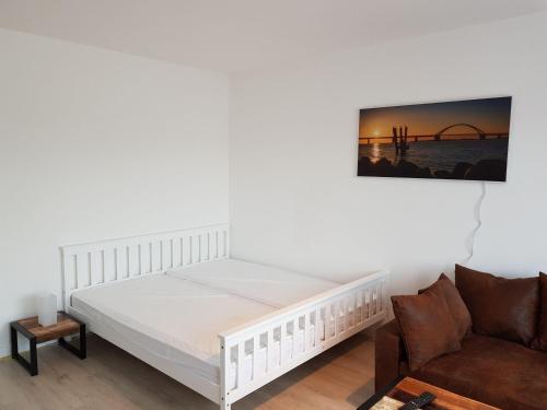 Burgtiefe auf Fehmarn にあるFewo-Strandnixeのベッドルーム(白いベッド1台、ソファ付)