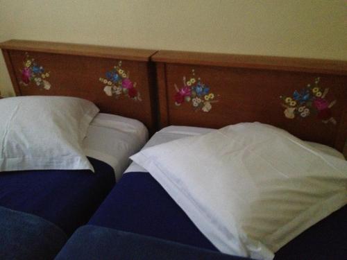 a bedroom with two beds and flowers on the wall at Hôtel Restaurant Wolf in Markstein 