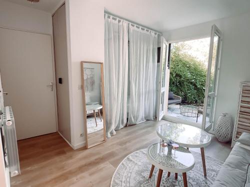 a living room with a couch and a table at Ravissant T1 avec jardinet proche de la mer in Hyères