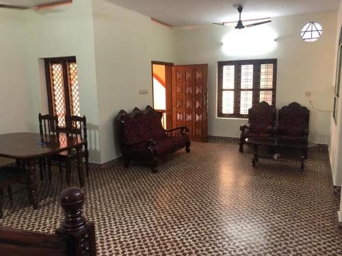 uma sala de estar com cadeiras e uma mesa e uma sala de jantar em Konni Town Central House with AC rooms em Koni