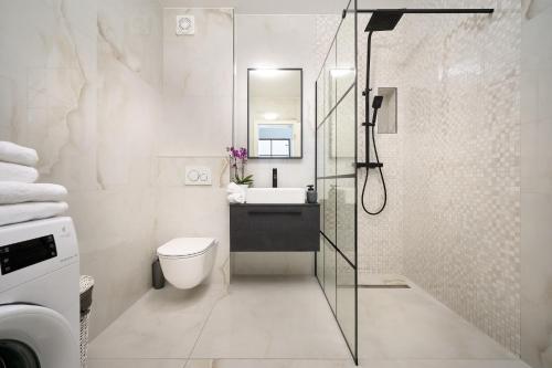 La salle de bains est pourvue de toilettes, d'un lavabo et d'une douche. dans l'établissement Klara Beach Apartment, à Split