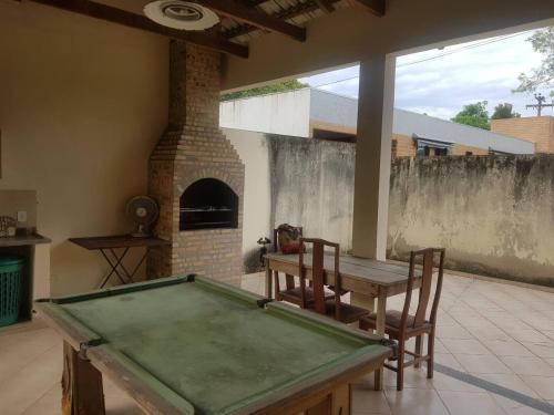 a pool table in a living room with a fireplace at Belissima casa em Itauna a 300 metros da praia in Saquarema
