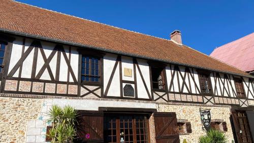 a black and white building with a brown roof at Domaine du Cellier de la Couronne in Sézanne