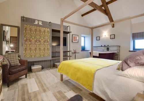 a bedroom with a bed and a chair and a desk at Tir Bach Iago in Llangwnadl