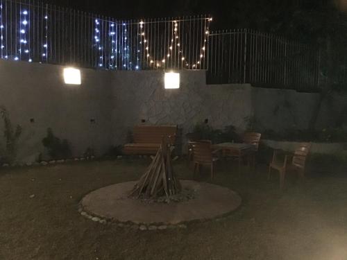 a patio with a table and chairs and lights at DreamCatcher By Samyati Hotels and Resorts in Bhīm Tāl