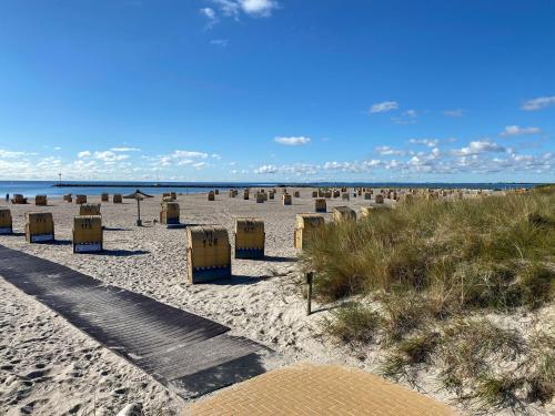 einen Strand mit Stühlen und das Meer im Hintergrund in der Unterkunft Homalux 1,5 Zimmer-Yachthafen / Südstrand in Burgtiefe auf Fehmarn 
