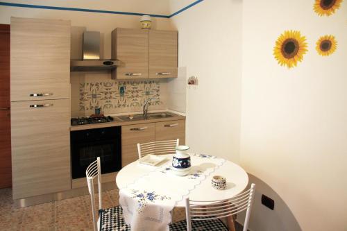 uma cozinha com mesa e cadeiras e uma cozinha com lavatório em Vacation Home Agrumeto Flegreo em Nápoles