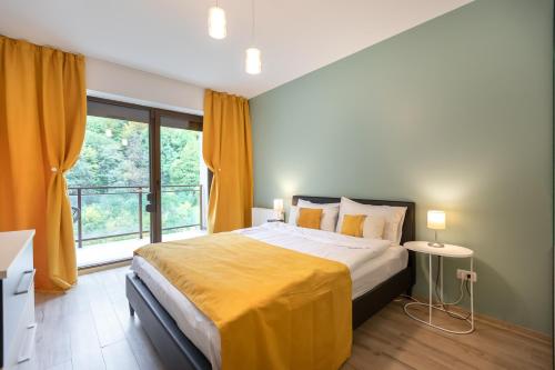 ein Schlafzimmer mit einem Bett und einem großen Fenster in der Unterkunft Tampa Gardens Apartments - Adults Only in Braşov