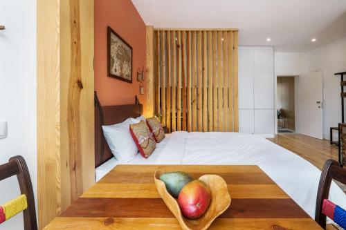 - une chambre avec un lit et une table avec un bol de fruits dans l'établissement São Vitor Studio w/ Patio by LovelyStay, à Porto