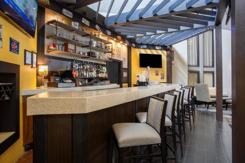 a bar with a row of stools in a restaurant at Holiday Inn Morgantown - Reading Area by IHG in Morgantown