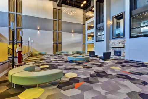 a lobby with a waiting area with chairs and a fireplace at Holiday Inn Morgantown - Reading Area by IHG in Morgantown