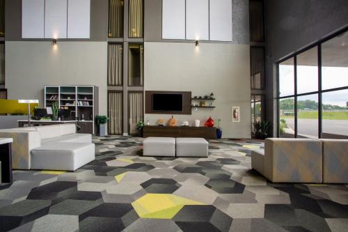 a large living room with couches and a television at Holiday Inn Morgantown - Reading Area by IHG in Morgantown