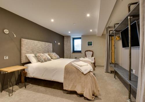 a bedroom with a large bed and a staircase at Llain Iago in Llangwnadl