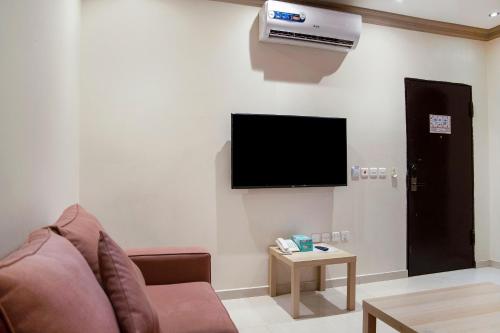 a living room with a couch and a flat screen tv at Wasn Suites in Riyadh