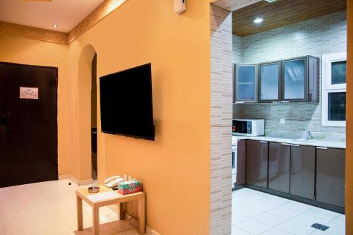 a large kitchen with a tv on the wall at Wasn Suites in Riyadh