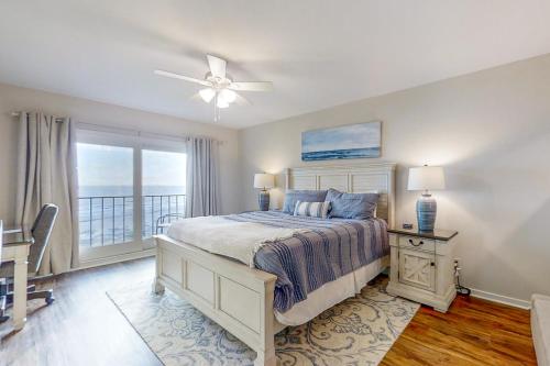 a bedroom with a bed with a ceiling fan and a window at Turtle Sea Dunes II in Fernandina Beach