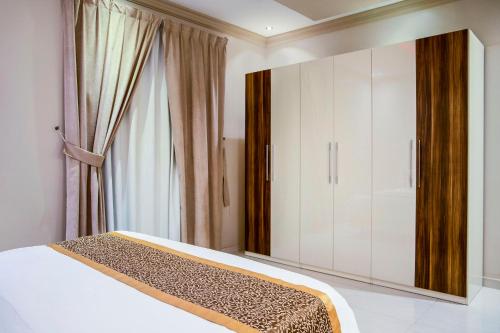 a bedroom with a bed and a large cabinet at Wasn Suites in Riyadh