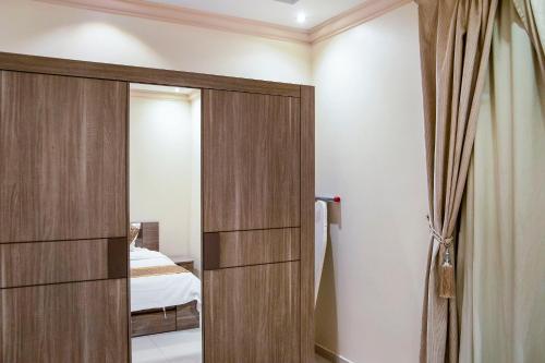 a door leading into a bedroom with a bed at Wasn Suites in Riyadh