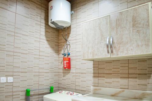 a bathroom with a toilet and a light on the wall at Wasn Suites in Riyadh