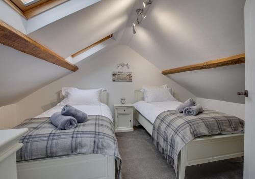 two twin beds in a attic bedroom with wooden beams at Dau Ddeg Tri in Conwy