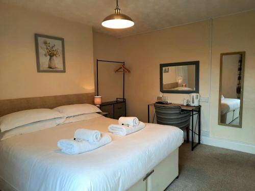 a bedroom with two beds with towels on them at The Grey Horse in Elvington