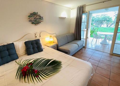 a bedroom with a large bed and a living room at Sur la Plage @ Pierre & Vacances in Sainte-Anne