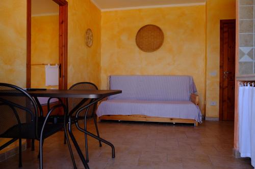 a small bedroom with a bed and a table at Case Vacanza Villa Doria in Valledoria