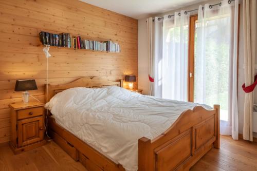 une chambre avec un lit et un mur en bois dans l'établissement JEANETTE 2, à Morzine