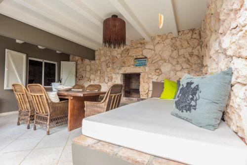 a living room with a couch and a stone wall at Casa Karlina in Palm-Eagle Beach