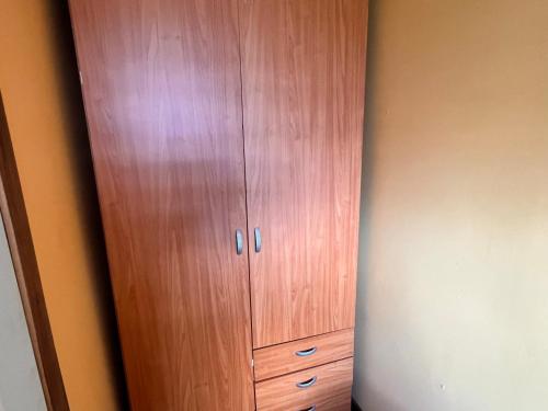 a wooden cabinet in the corner of a room at Hostal Mirador Quellón in Quellón