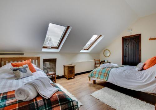 two beds in a room with skylights at Dan y Comin in Sennybridge