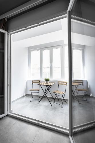 a room with a table and chairs through a sliding glass door at Adelle Apartments, The Luxury Suites in Thessaloniki