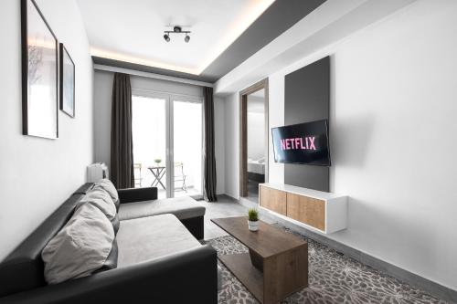 a living room with a couch and a tv at Adelle Apartments, The Luxury Suites in Thessaloniki