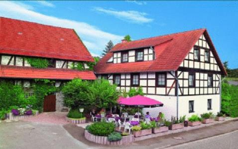 a building with a table and chairs in front of it at Landgasthof & Hotel Jossatal in Breitenbach am Herzberg