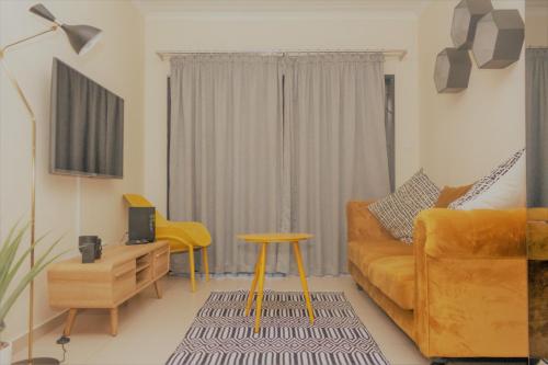 sala de estar con sofá amarillo y mesa en Ground Floor Apartment Midrand en Midrand