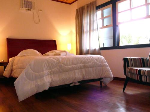 a bedroom with a bed with a dog laying on it at Pouso da Chica in Diamantina