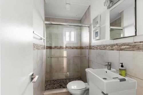 een badkamer met een douche, een toilet en een wastafel bij 10 Cayuga in Ocean Bay Park