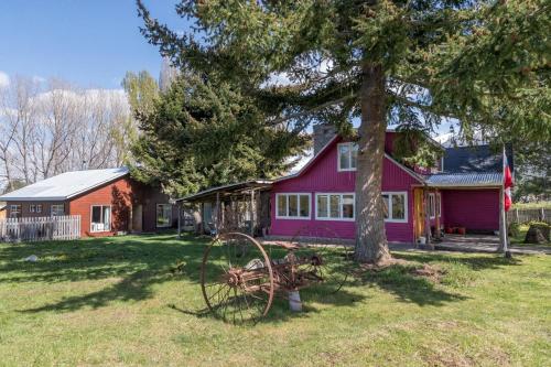 a purple house with a tree in the yard at La Casona, baño Compartido in Villa Cerro Castillo