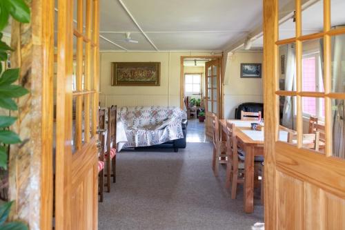 a room with a bed and a table and chairs at La Casona, baño Compartido in Villa Cerro Castillo