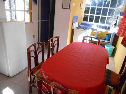 a kitchen with a red table and chairs in a room at Hotel y Bungalows Monteverde in Chachalacas
