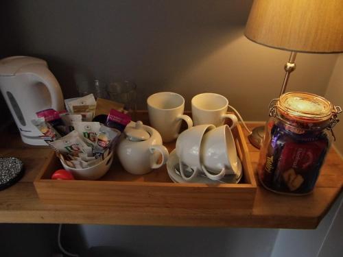a wooden tray with cups and mugs on a table at The Mill at Glynhir in Ammanford