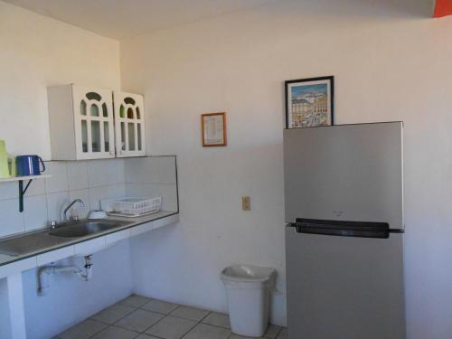 a kitchen with a sink and a refrigerator at Hotel y Bungalows Monteverde in Chachalacas