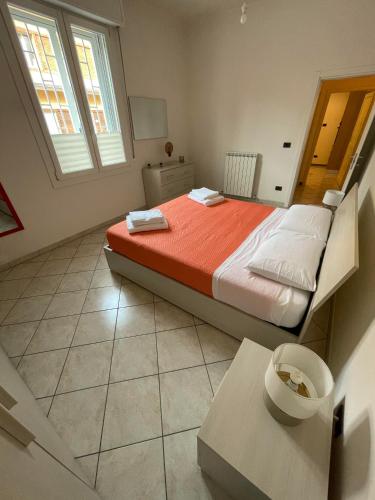 ein Schlafzimmer mit einem Bett mit orangefarbener Bettwäsche und einem Fenster in der Unterkunft FEELS LIKE HOME in Bologna