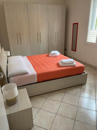 a bedroom with a bed with orange and white sheets at FEELS LIKE HOME in Bologna