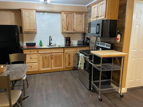 a kitchen with wooden cabinets and a black stove top oven at Relaxing River Family Retreat in Bullhead City