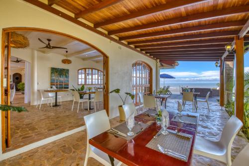 uma sala de jantar com mesa e cadeiras e o oceano em El Castillo - Adults only em Ojochal