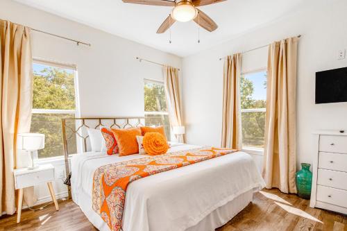 sypialnia z łóżkiem z pomarańczowymi poduszkami i wentylatorem sufitowym w obiekcie The Secret Cabin w mieście Burnet