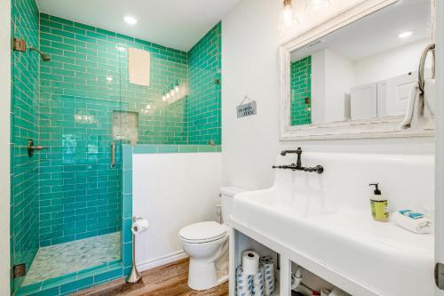 W łazience znajduje się umywalka i prysznic z niebieskimi kafelkami. w obiekcie The Secret Cabin w mieście Burnet